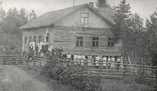 Alkup. kuva Elli Ronko, Jämsä,  (c) Keski-Suomen museon kuva-arkisto,  Hassin työväentalolla 1914 pidetyt kesäjuhlat. Työväentalon rappusilla yhdistysväkeä ja nurmikolla urheiluseura Hassinkylän Kisatoverien voimistelujoukkue voimistelusauvoineen asennossa.